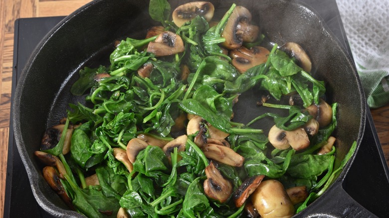 Spinach and mushrooms in a frying pan