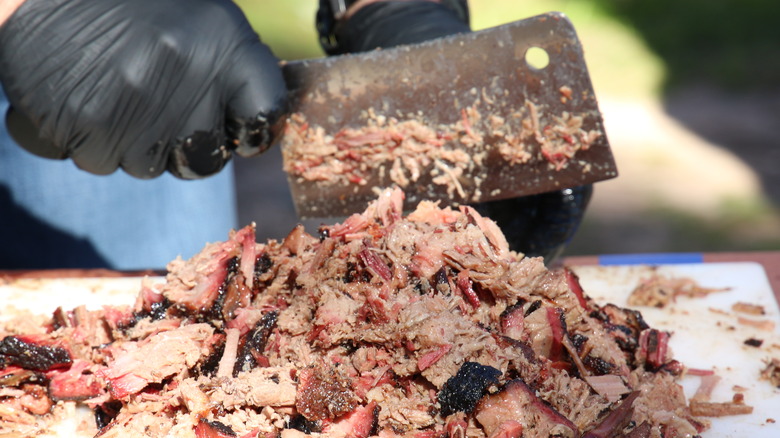 Chopping beef brisket with cleaver