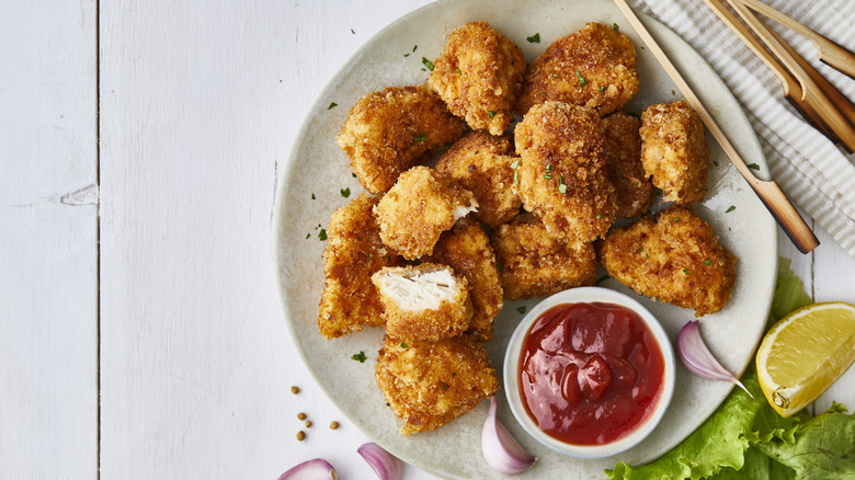 Chicken nuggets on a plate with ketchup