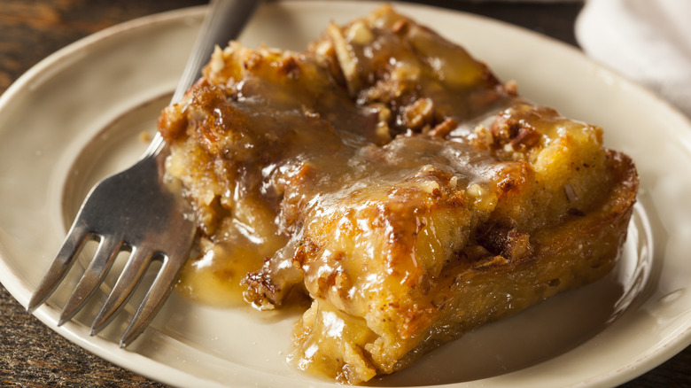 A gooey slice of bread pudding topped with caramel sauce