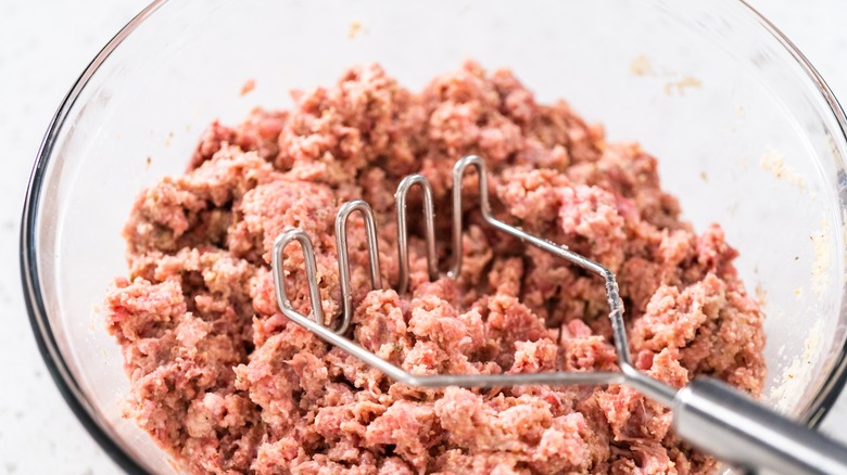 a potato masher in ground meat