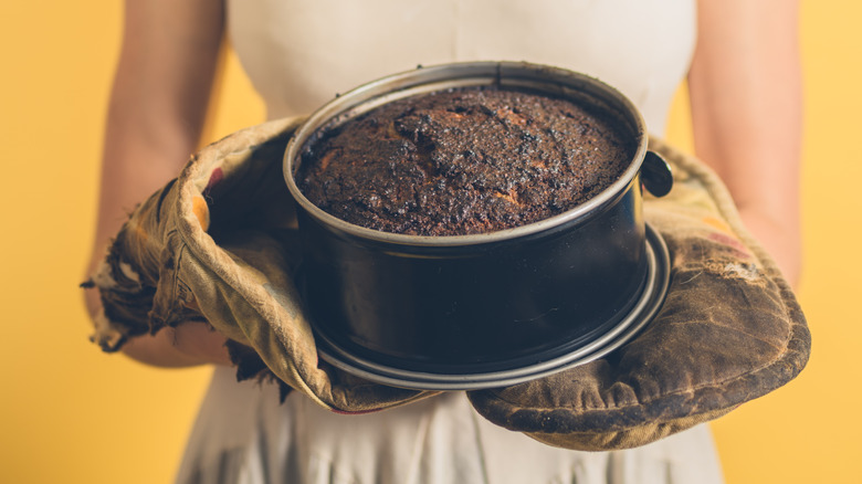 woman holding a burnt cake