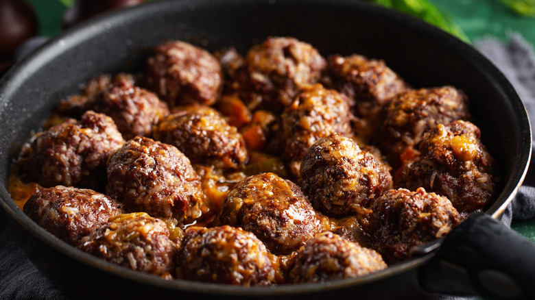 meatballs cooking in sauce in a skillet