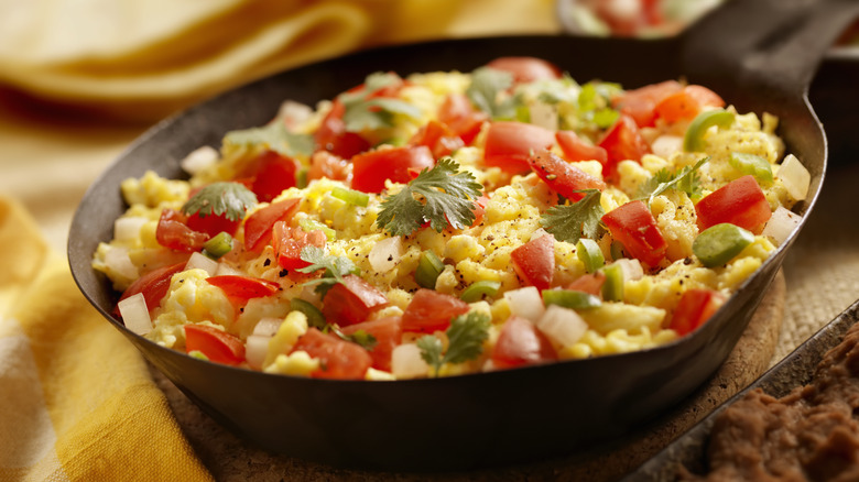 scrambled eggs and vegetables in a skillet