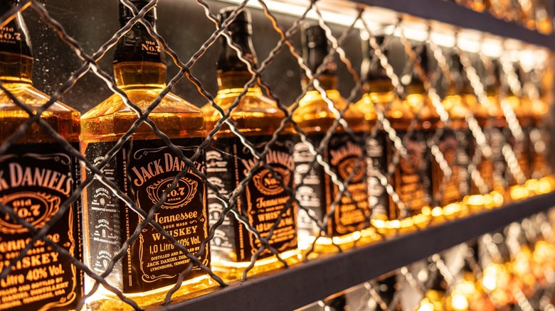 Bottles of Jack Daniel's whiskey behind chain-link