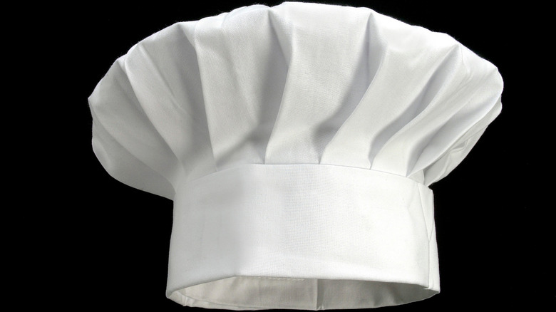 A chef's hat against a black background