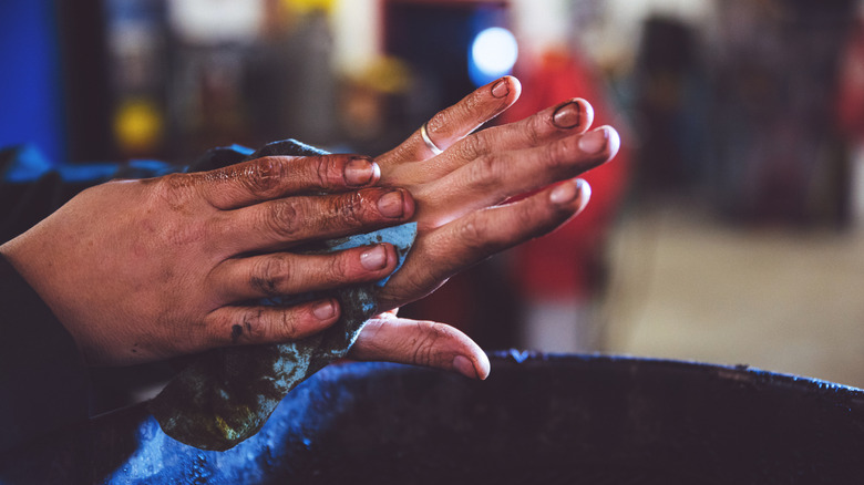 A pair of hands covered in grease