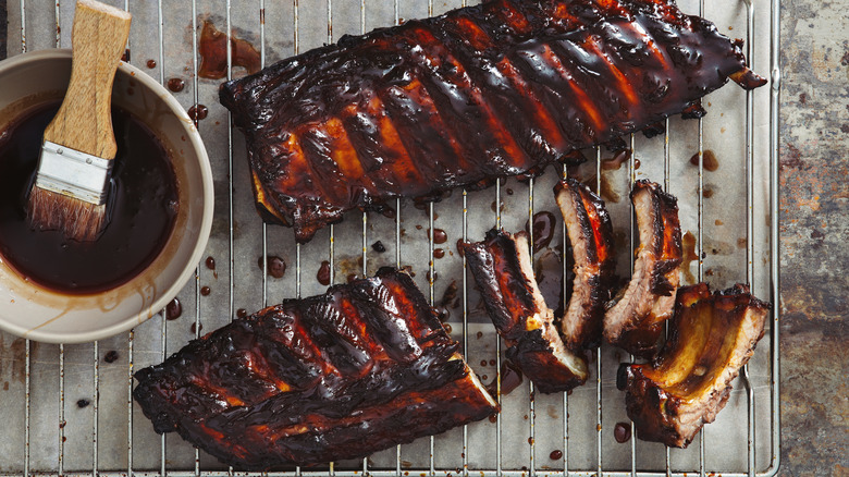 bowl of barbecue sauce and rack of ribs