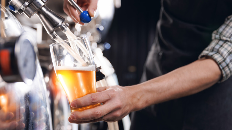 Brewer pouring beer at brewery