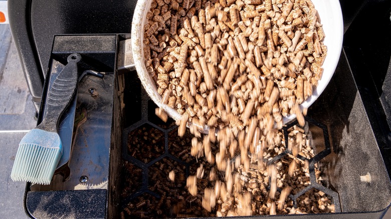 adding wood pellets to smoker