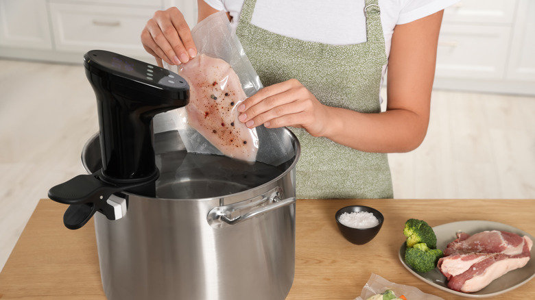 A woman cooking chicken breast sous vide