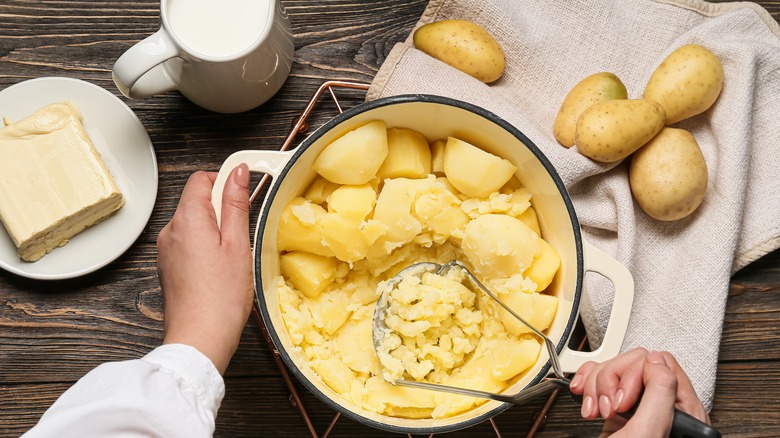 Person mashing potatoes