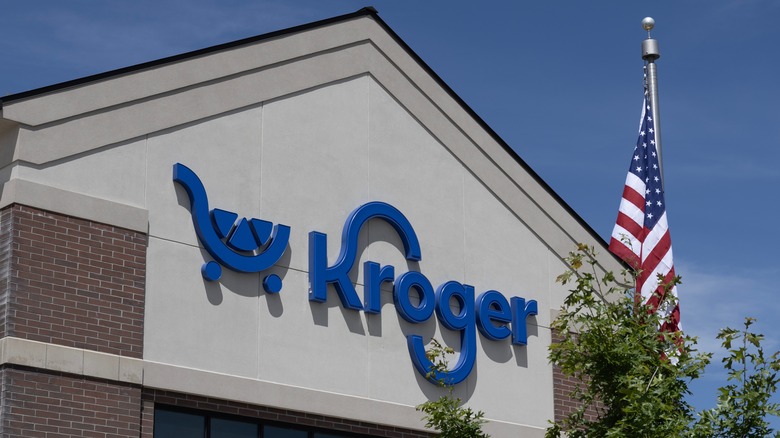 Kroger grocery store sign with a tree and an American flag