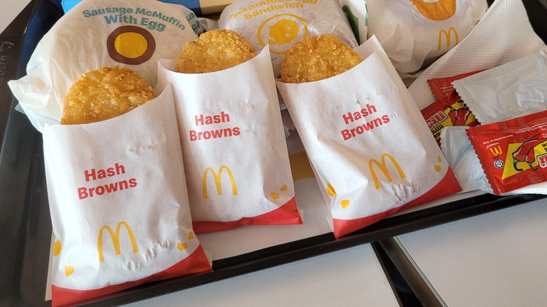 A dine-in tray with 3 McDonald's hash browns and 3 breakfast sandwiches.