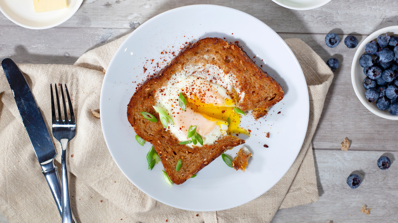 Egg in a hole cut open with silverware