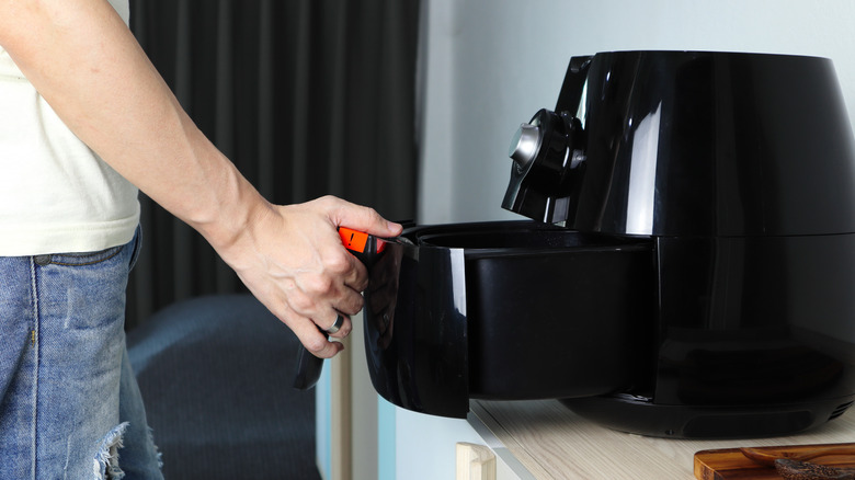 man pulling air fryer basket