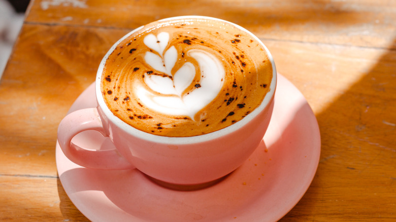 perfect cappuccino with heart design in a pink mug