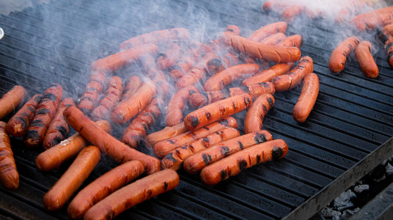 hot dogs with horizontal slices on grill