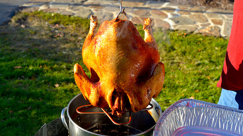 pulling a whole turkey out of a deep fryer