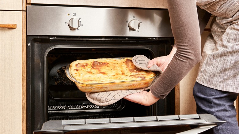Removing baked lasagna from oven