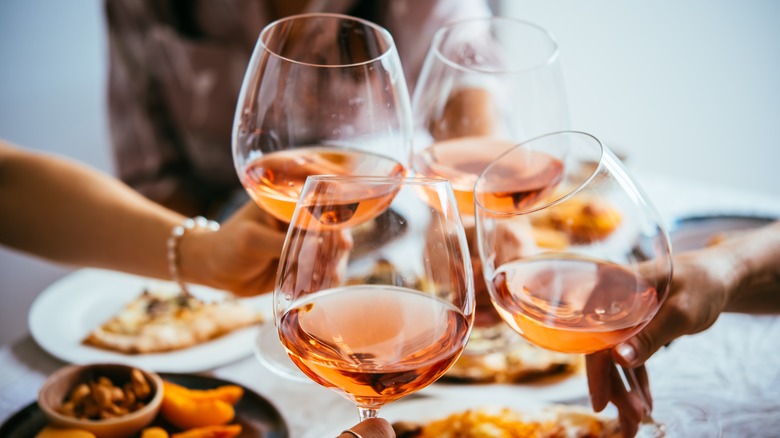 Clinking glasses of rosé wine