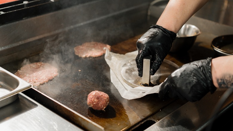 Hands making a smash burger