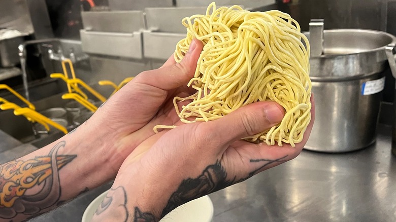 fresh ramen noodles in chef's hands