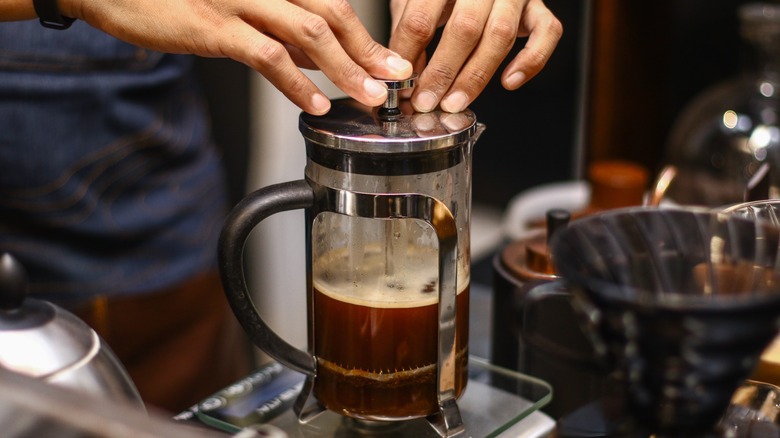 Person making coffee with a French press.