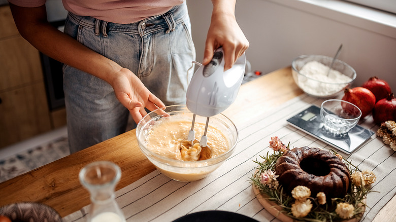 Person using hand mixer with a bowl of batter