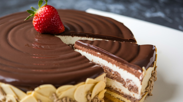 Boston cream pie with slice taken out on white surface