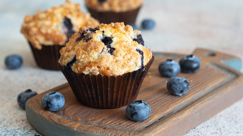 Classic blueberry muffin on wooden cutting board