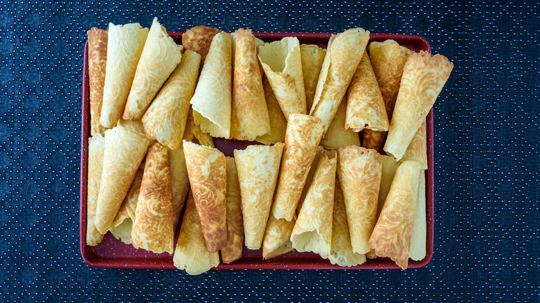 North Dakota krumkake cookies stacked on red platter with a blue background