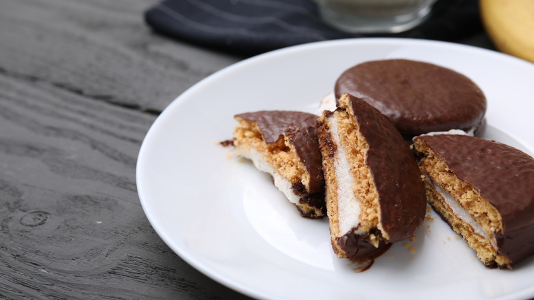 White plate filled with chocolate-covered moon pies on a grey wooden table