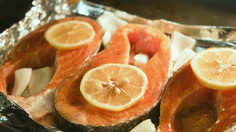 Thick-cut salmon filets on foil with onion and lemon