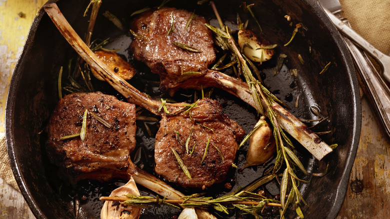 Lamb chops in cast iron pan with rosemary and garlic