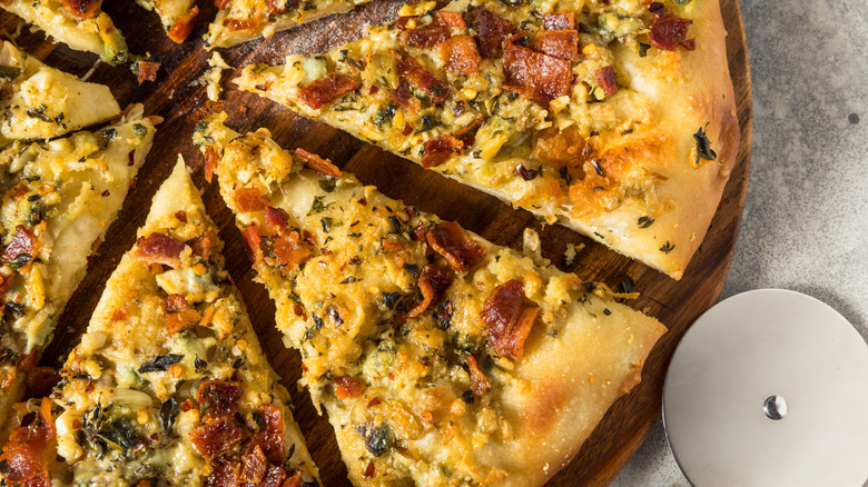 Sliced white clam pizza on wood board