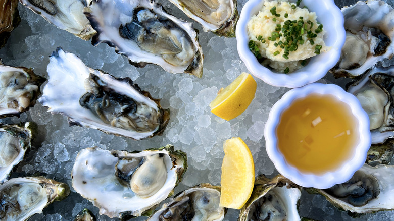 Raw West coast oysters on ice with dips and lemon wedges