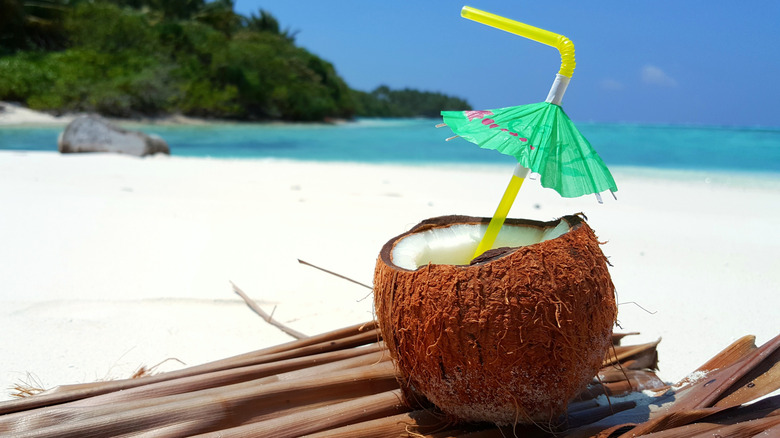 Coconut cocktail with umbrella straw on beach