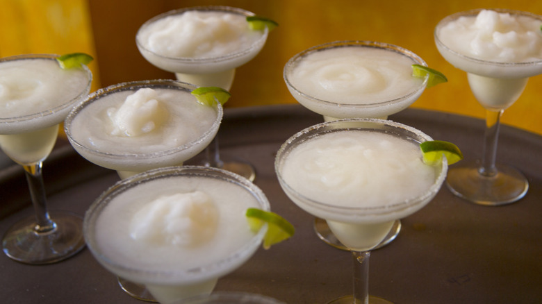 Frozen margaritas with lime wedges