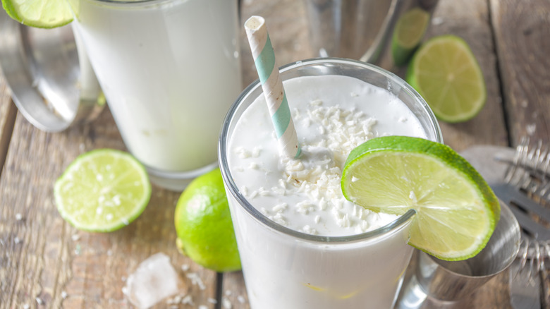 Coconut limeade drink with a lime wedge and straw