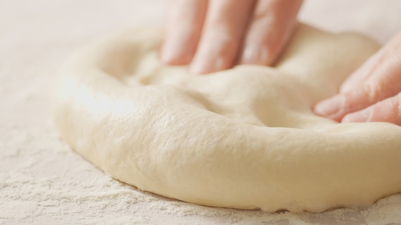 Hands stretching pizza dough