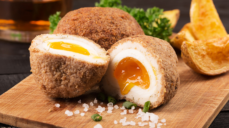 halved scotch eggs on a cutting board