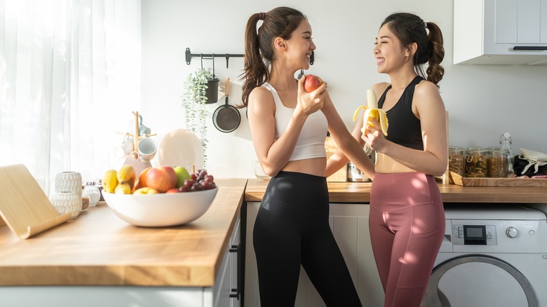 two women holding fruit