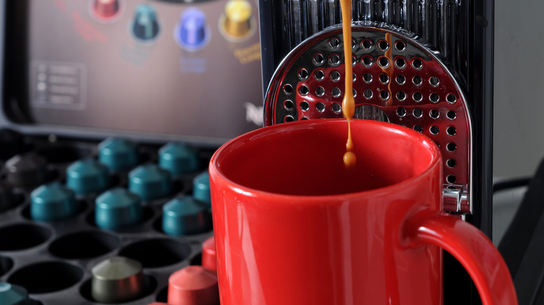 Close-up of a Nespresso machine pouring coffee into a mug