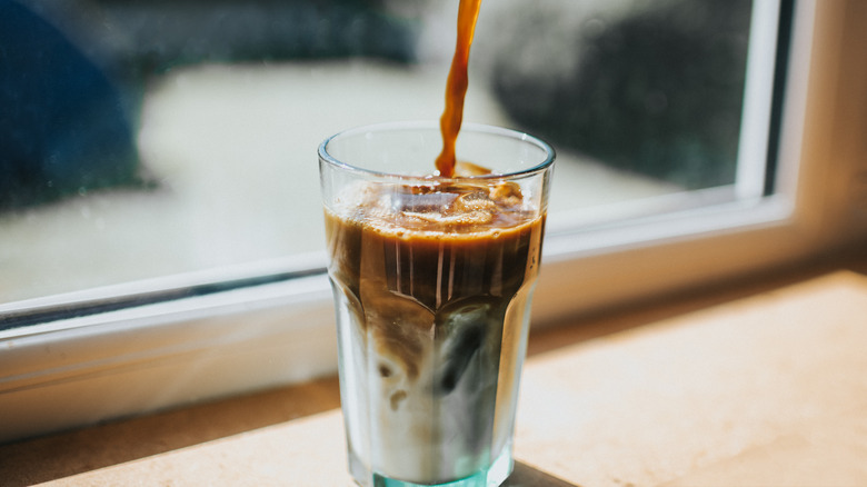 Espresso pouring into iced latte