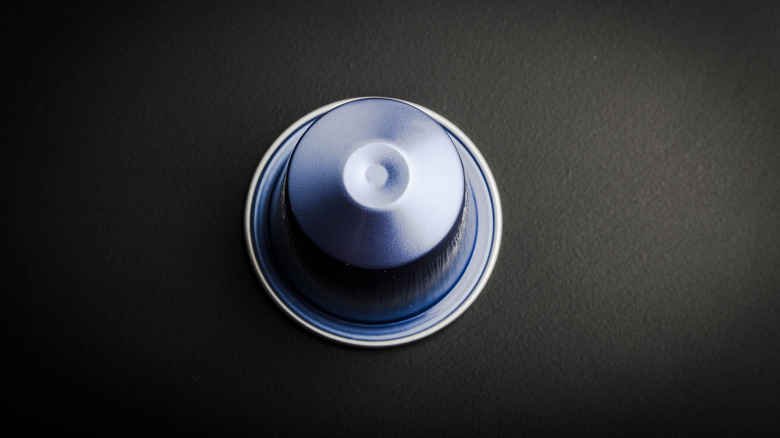 blue Nespresso pod on dark surface