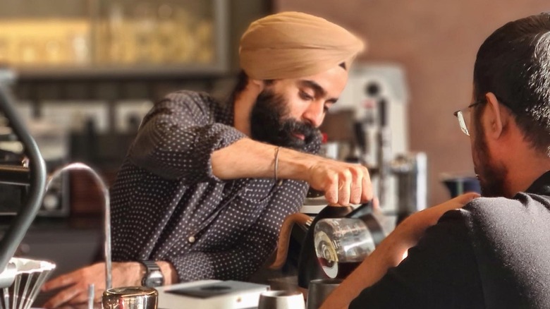 Baninder Singh pouring coffee