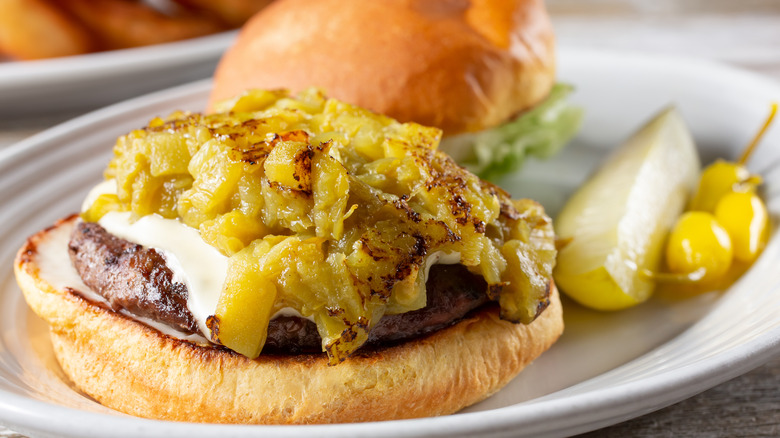 Green chilies on a cheeseburger