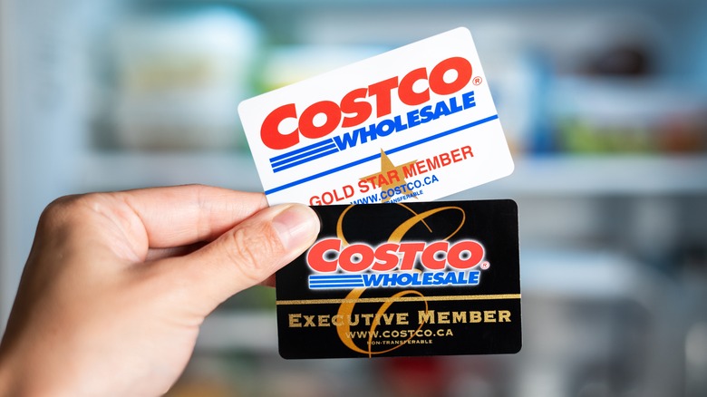 Costco membership cards held between fingers