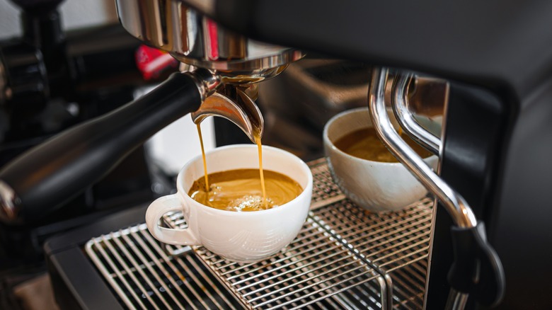 Professional espresso machine dispensing coffee into white ceramic mug